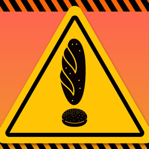 A triangular caution sign with the exclamation point made out of bread products