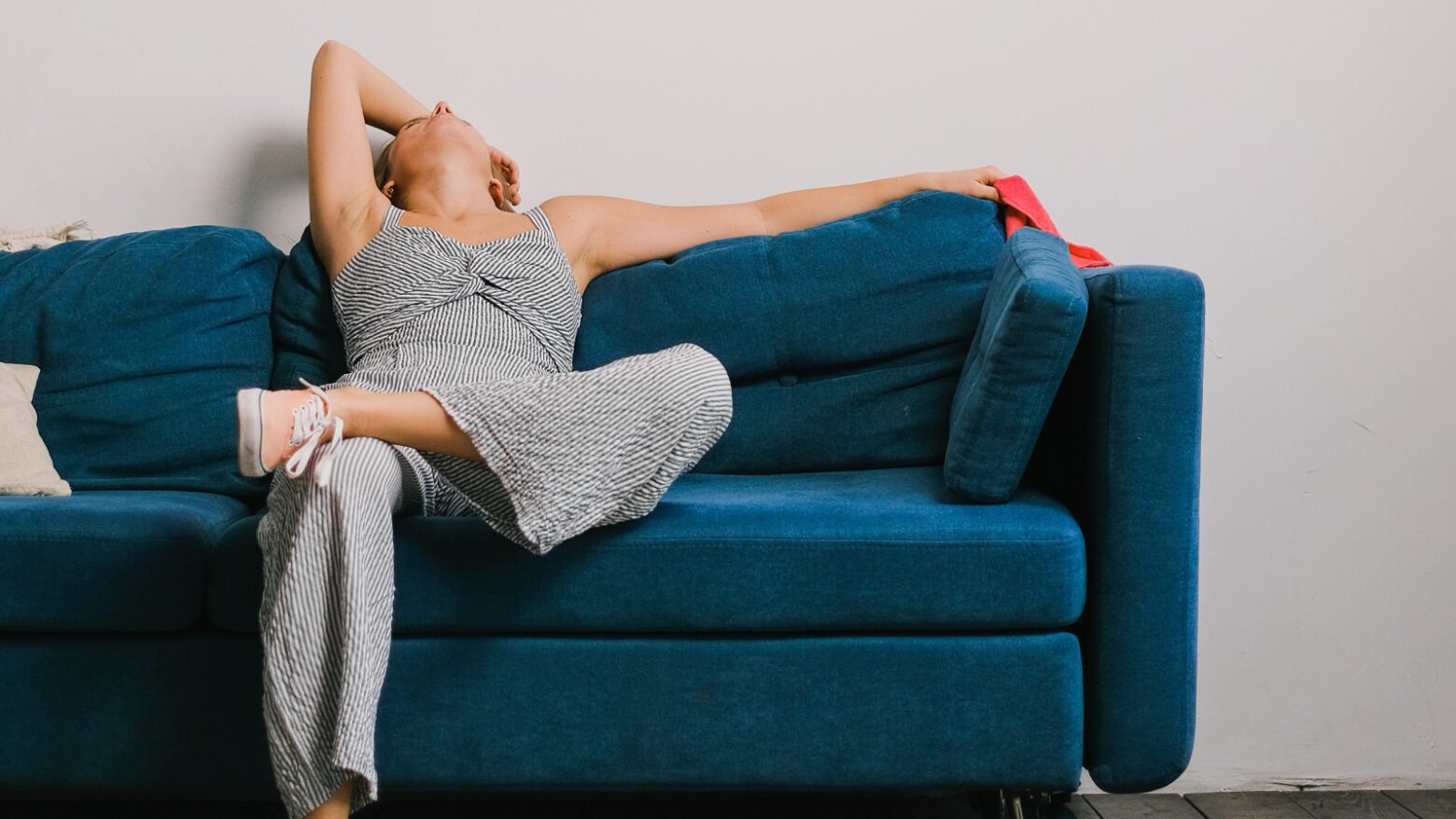 Exhausted woman lying back on a couch