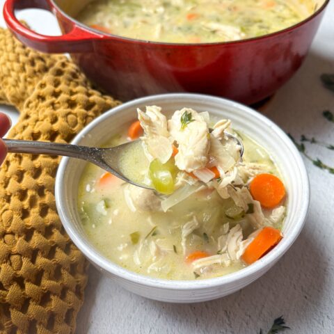 Chicken pot pie soup in a single bowl, with a spoon.