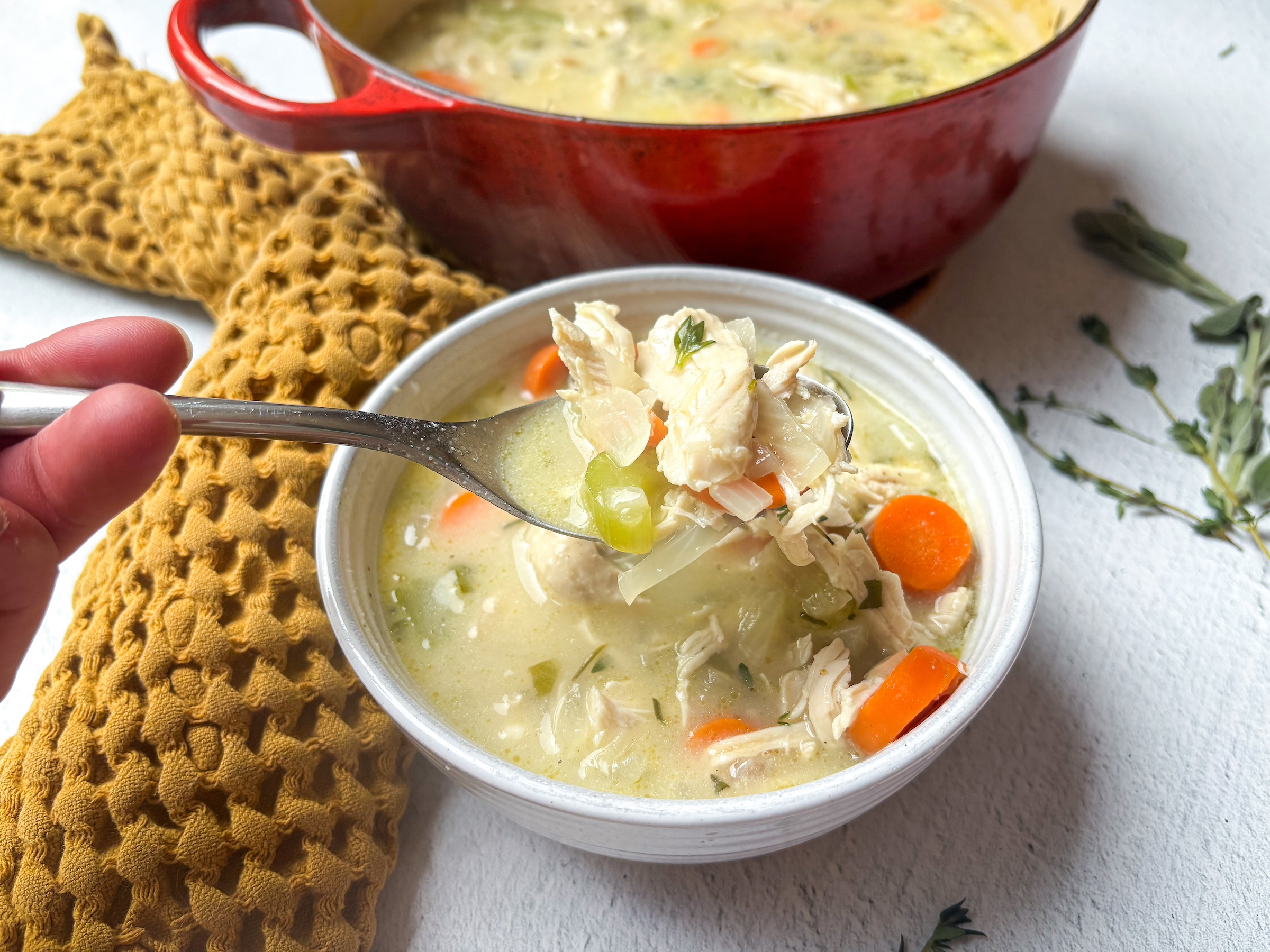 Chicken pot pie soup in a single bowl, with a spoon. 