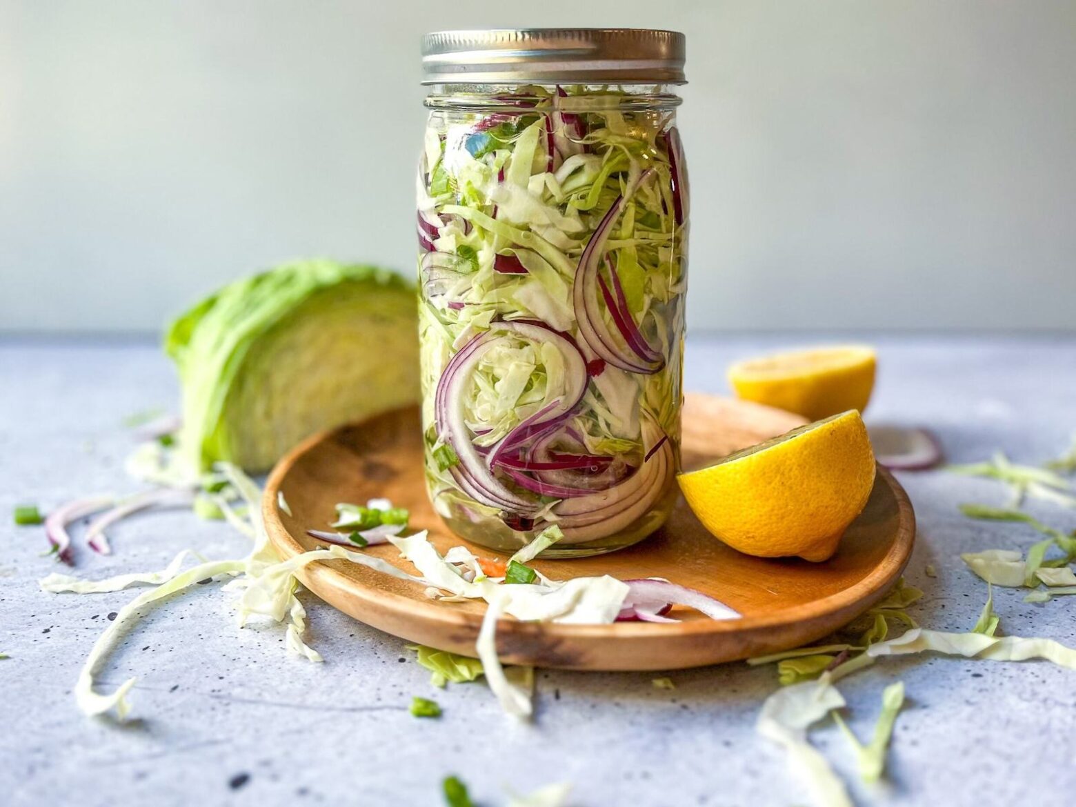 Low-sodium kimchi in a mason jar surrounded by kimchi ingredients