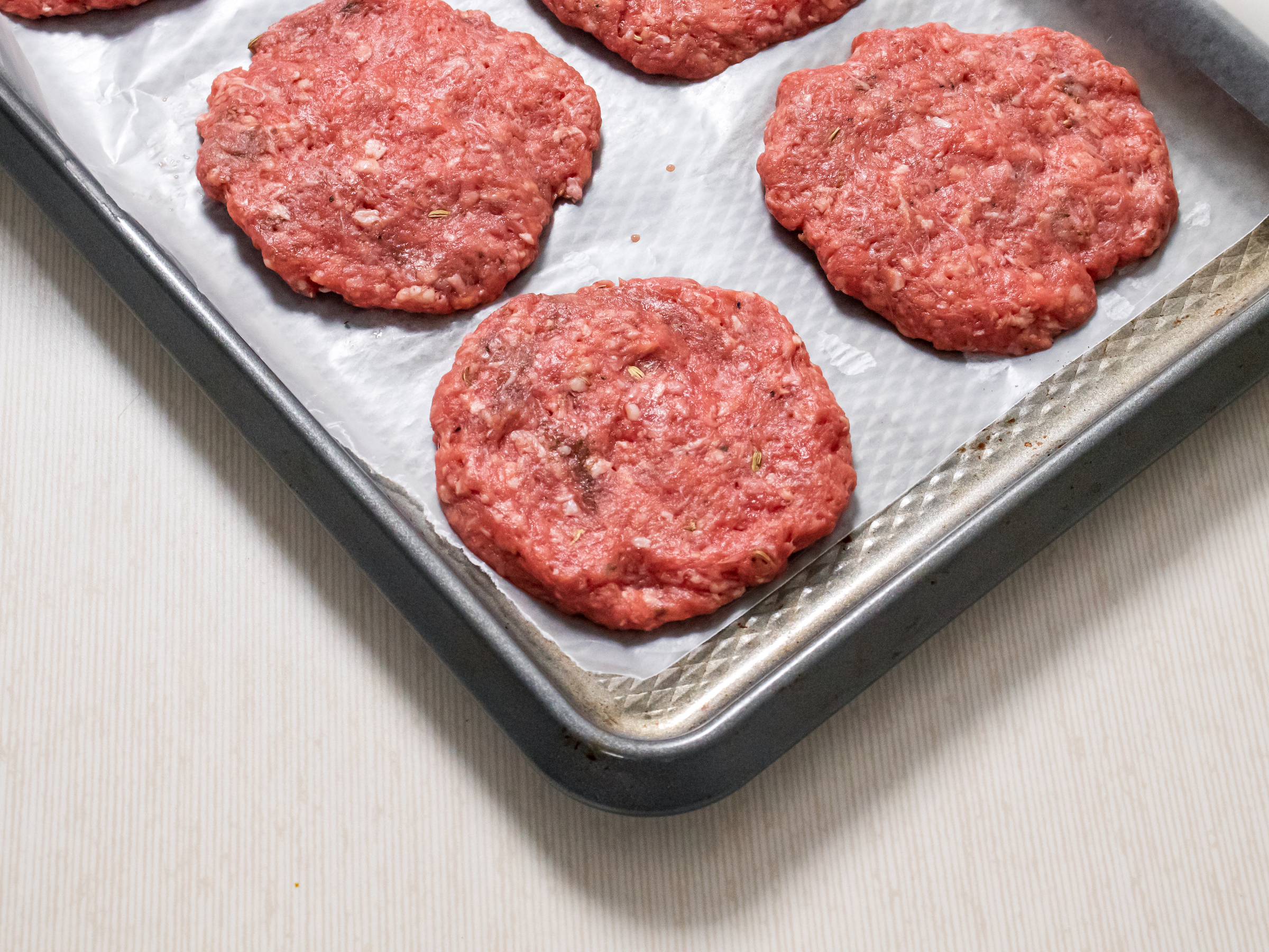 Homemade Bison Breakfast Sausages raw patties on the pan