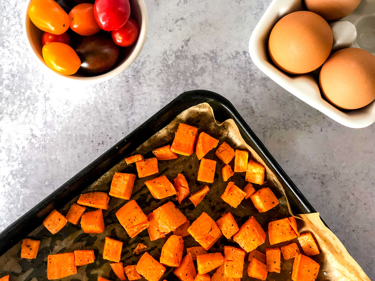 Sweet potatoes on a baking sheet being prepped from a Vegetarian Breakfast Buddha Bowl. 