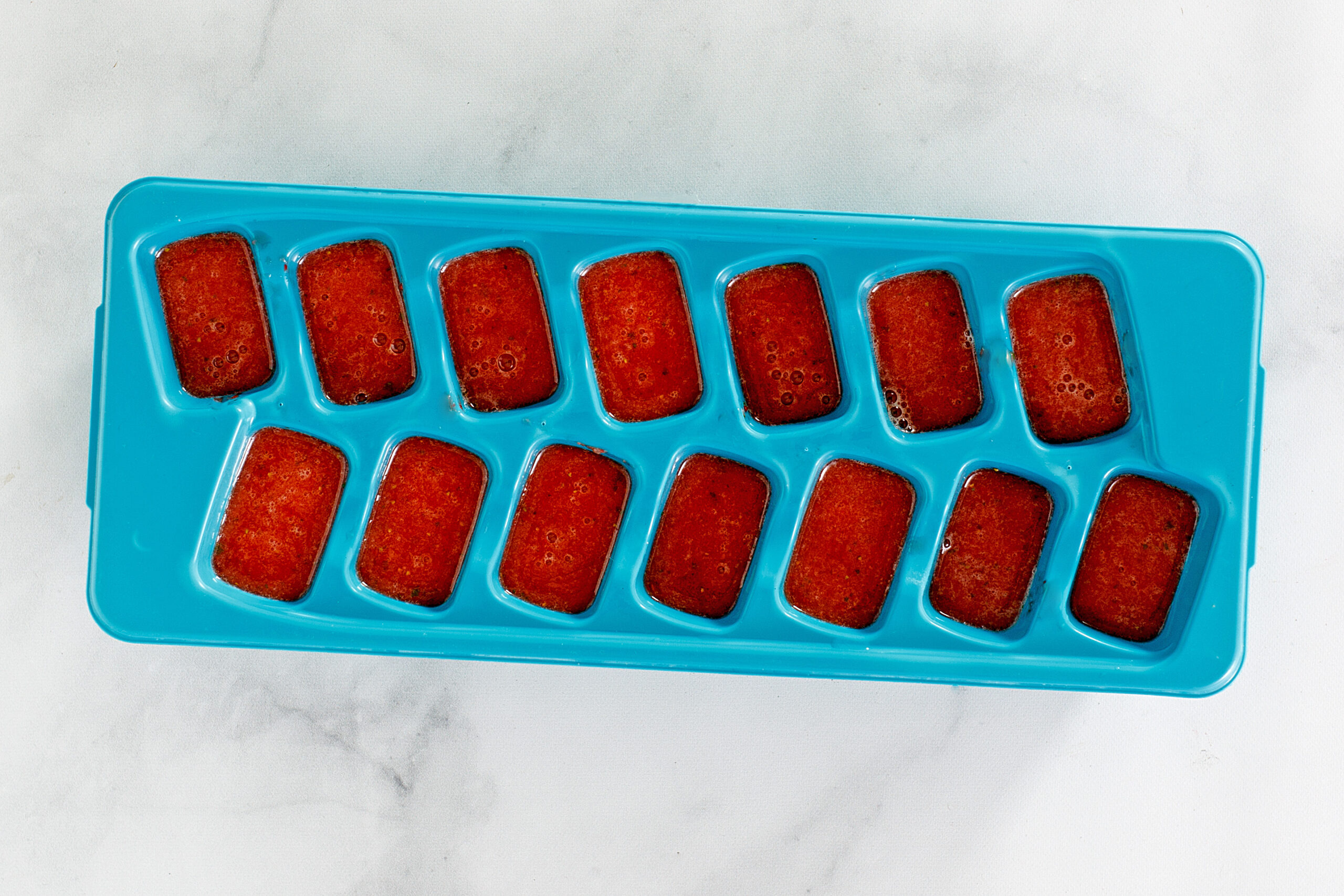 Strawberry lime iced tea ice cubes in the ice tray. 