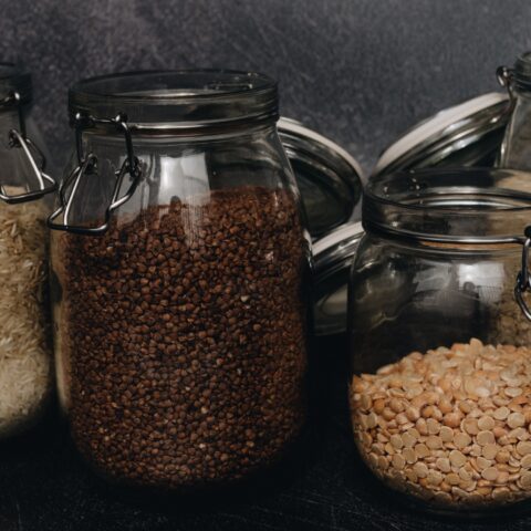 Jars of whole grains against a black background