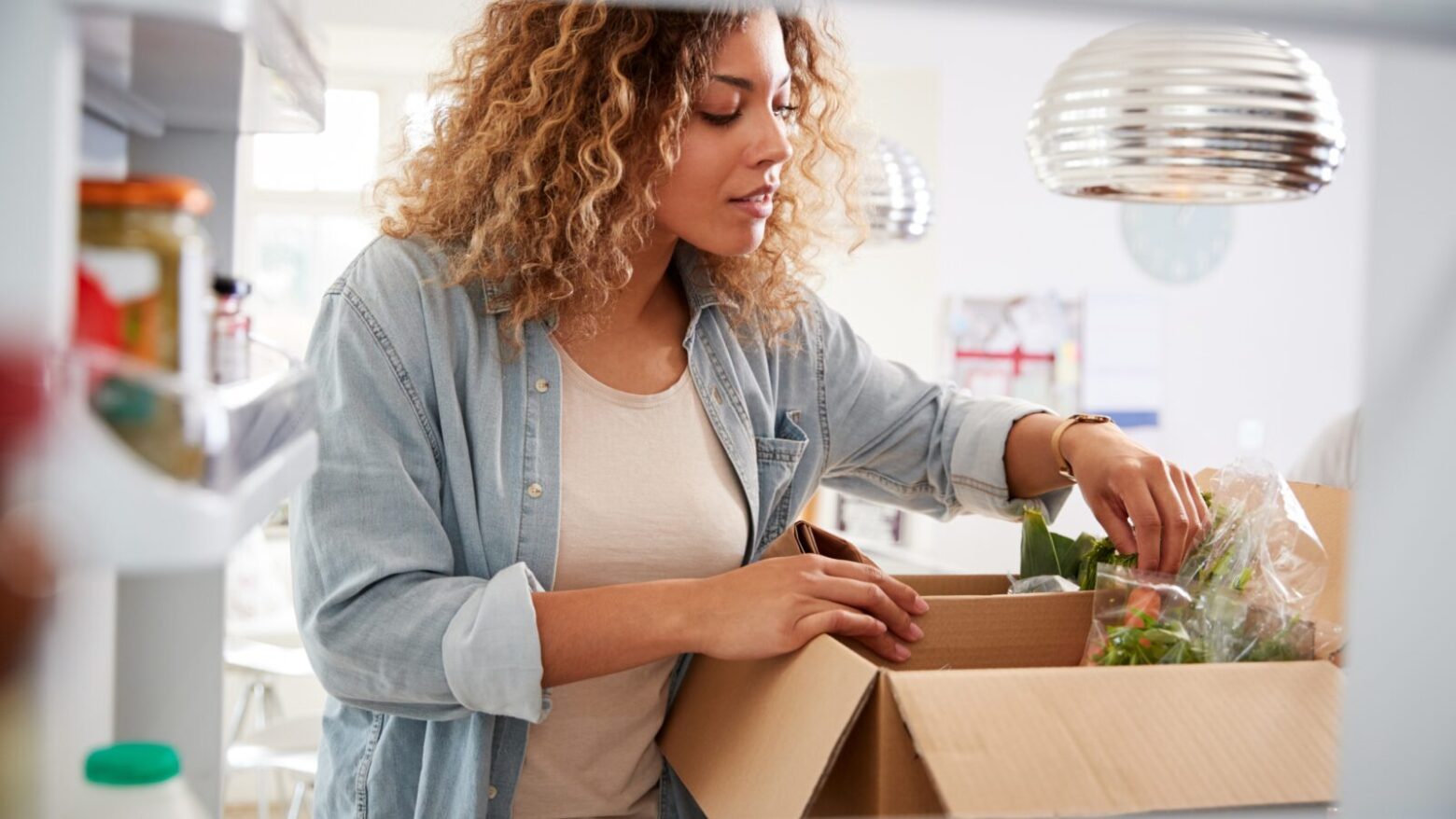 Woman unpacking produce in her kitchen.