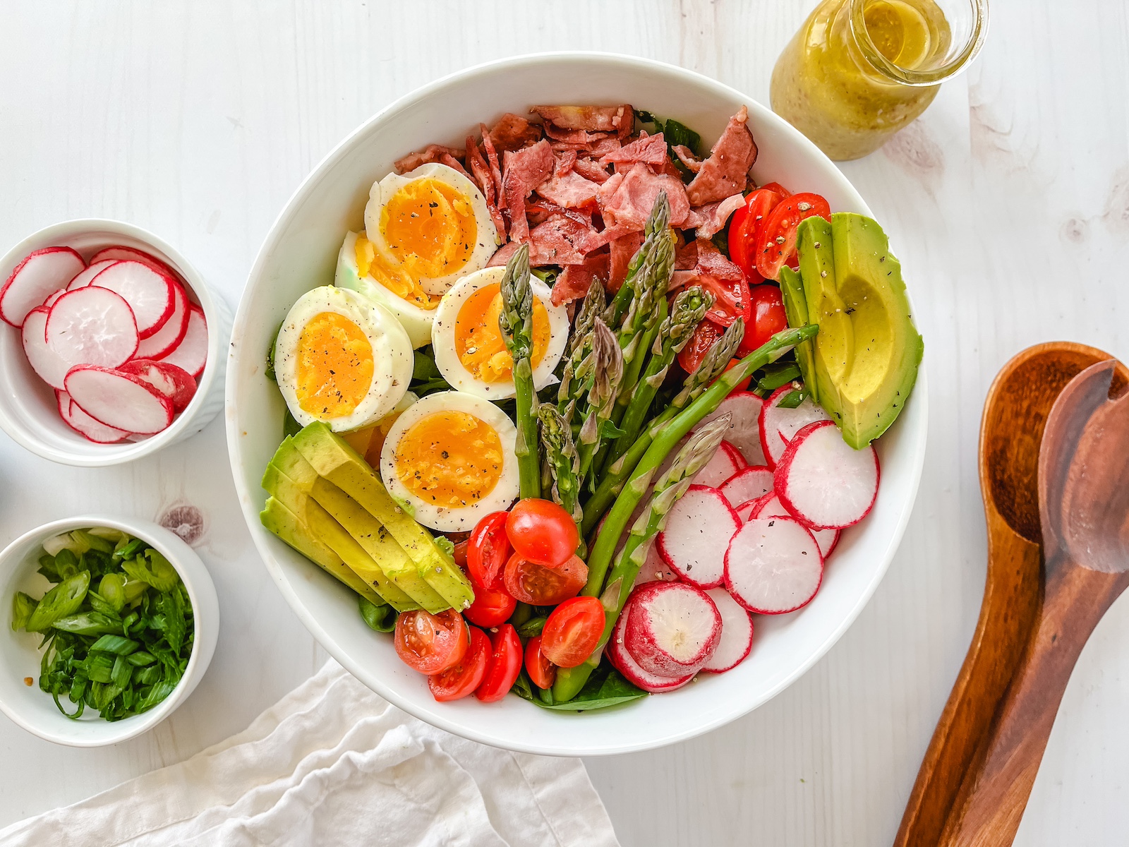 Spring cobb salad in a bowl with spoons on the side