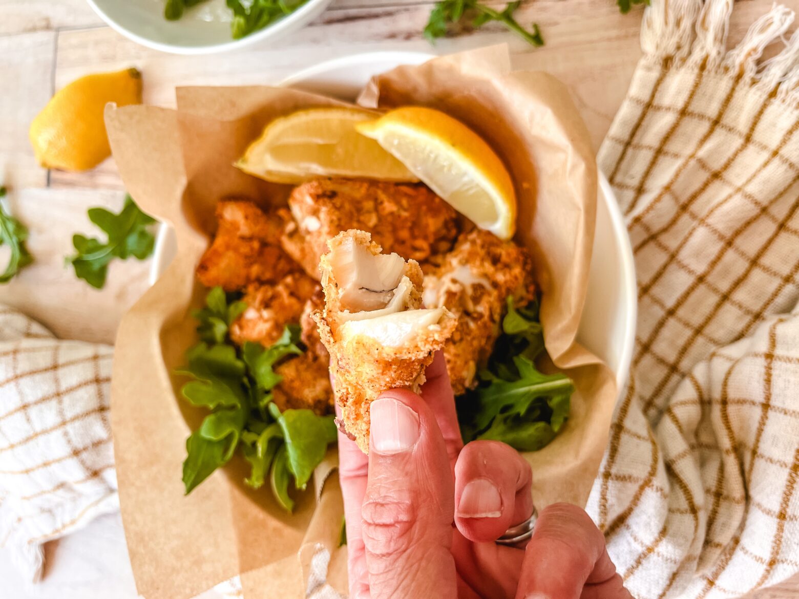 Air fryer fish sticks being held in front of the camera.
