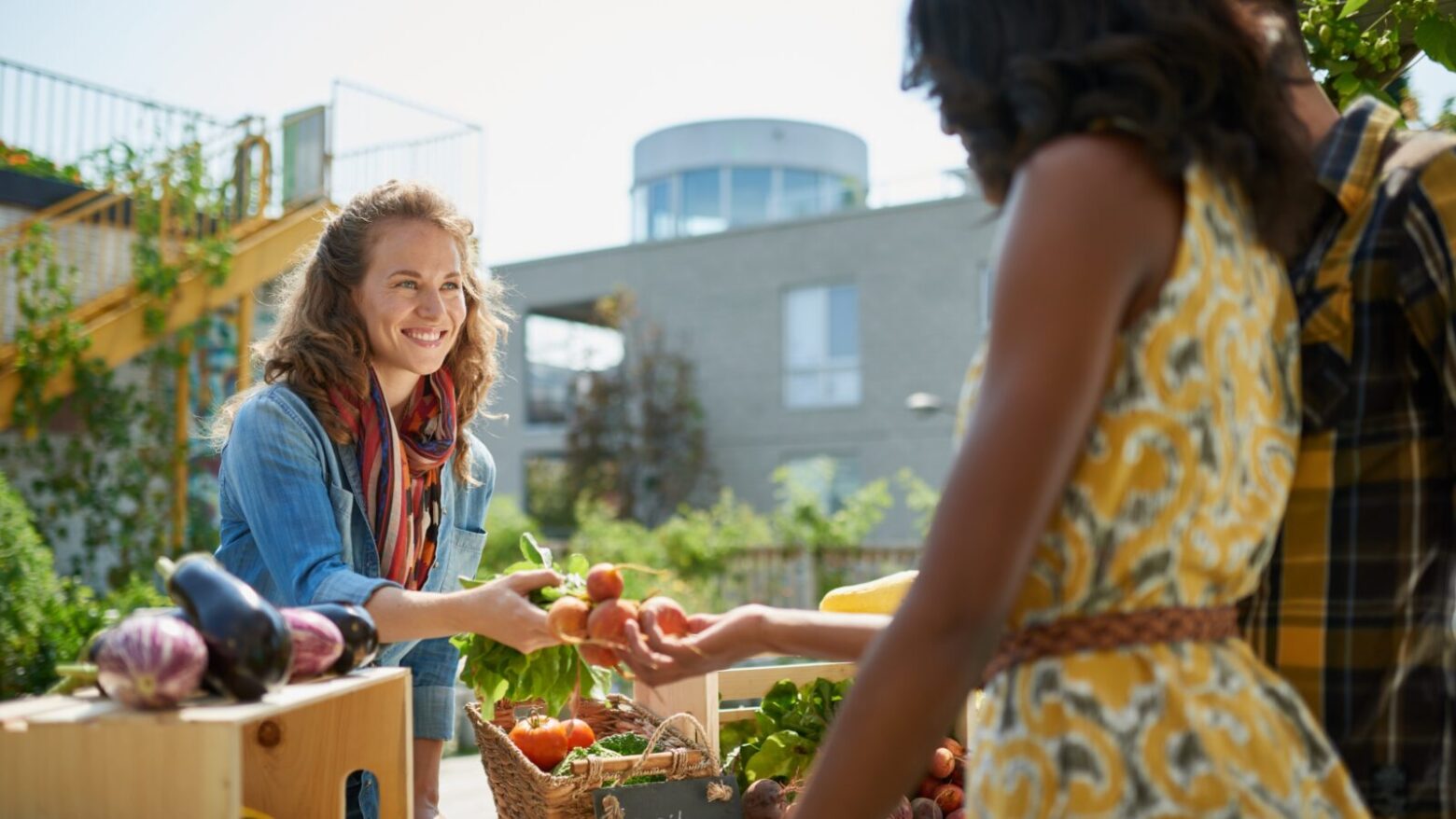 Woman buying produce at an outdoor market.