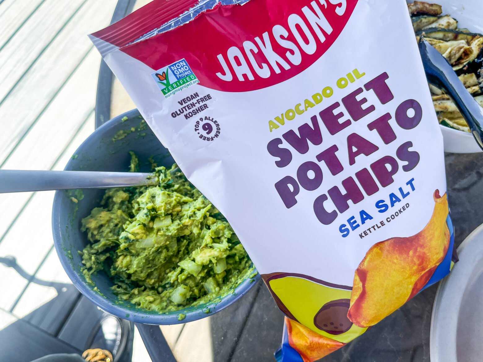 Bowl of guacamole next to the Jackson's Chips bag.
