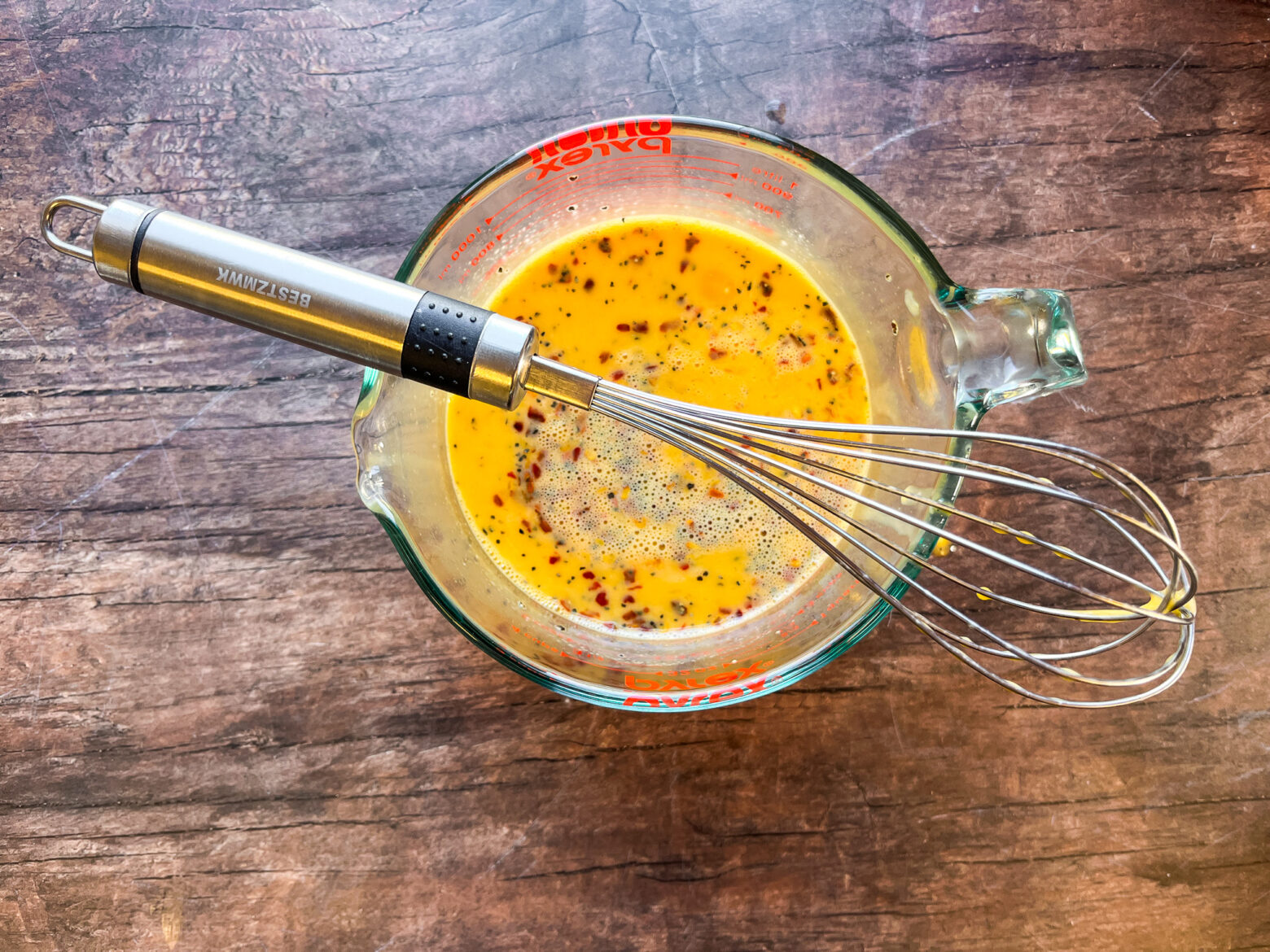 Egg wrap batter in a measuring cup with a whisk.
