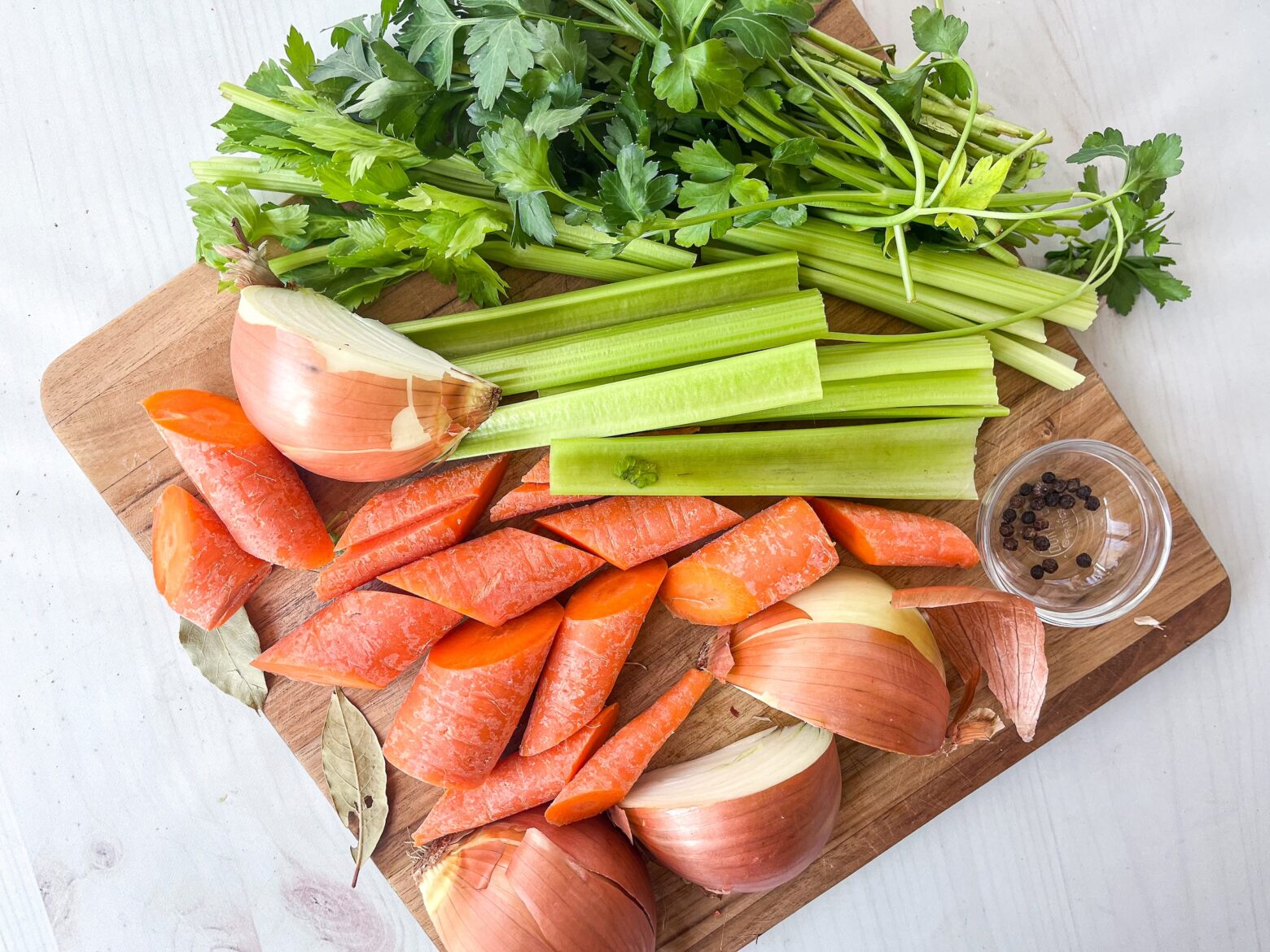 Chicken bone broth prep with chopped veggies.