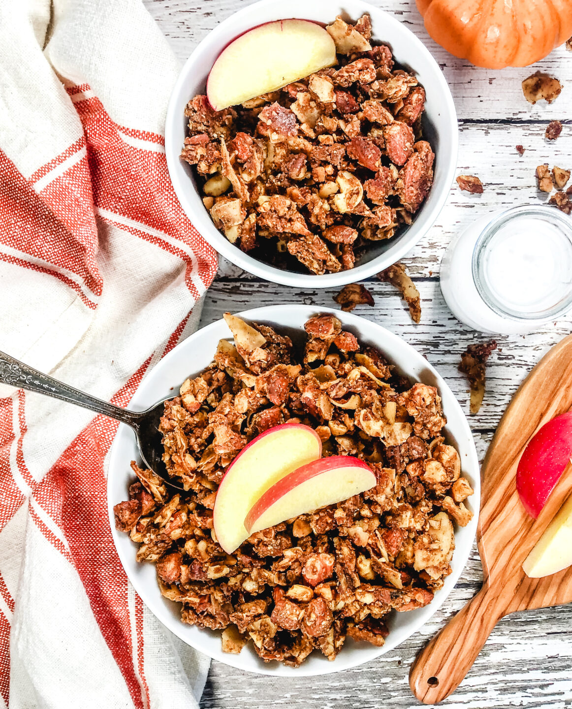 Pumpkin spice granola in a bowl topped with apple slices