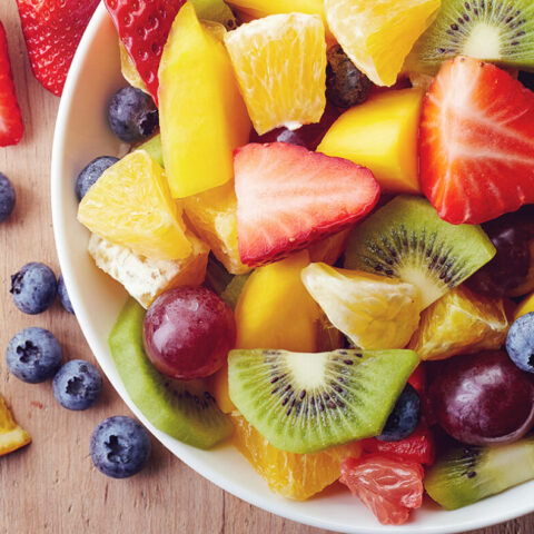 A bowl of colorful, chopped fresh fruits.