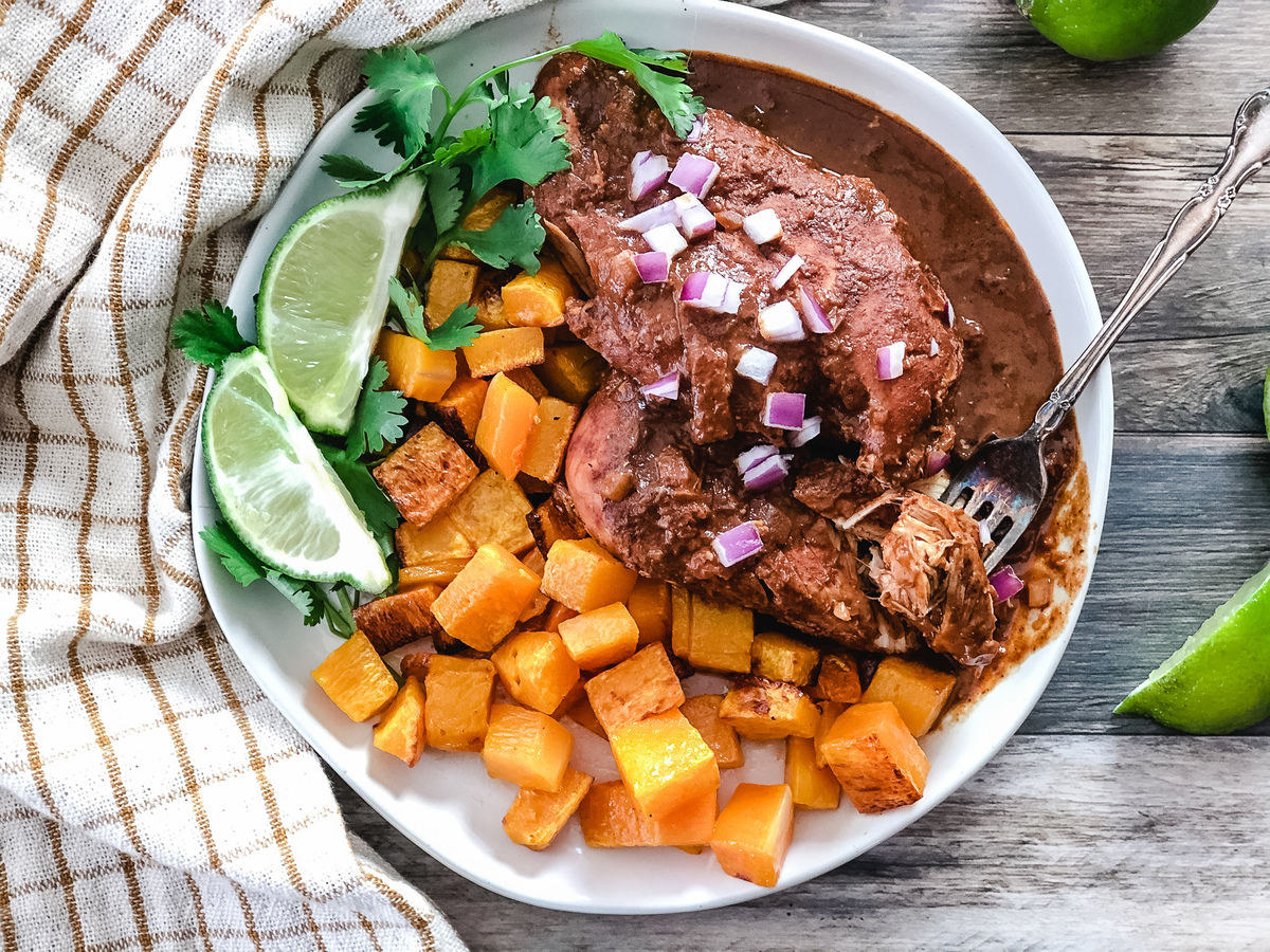 Slow cooker chicken mole on a plate with roasted butternut squash