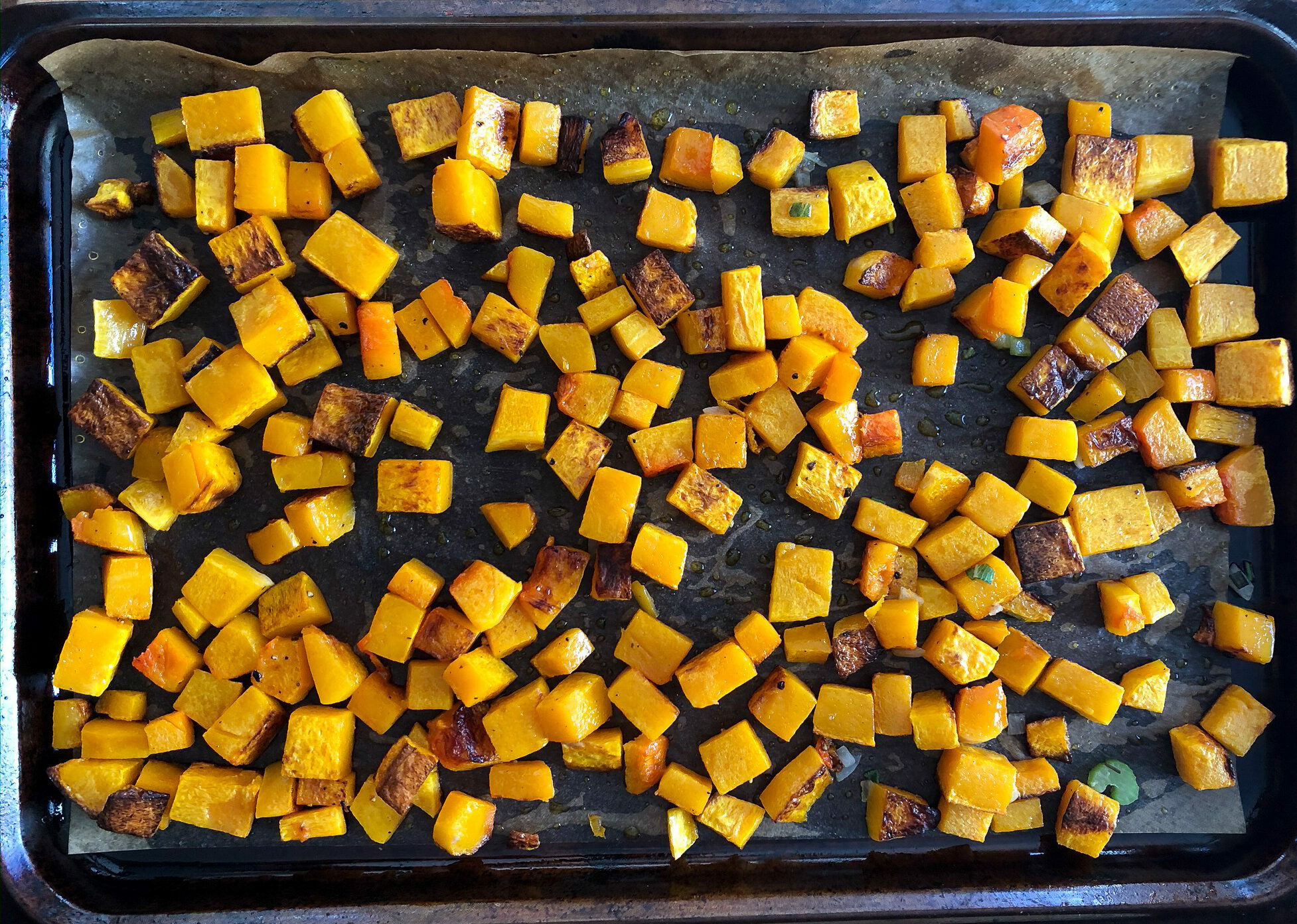 Diced butternut squash on a roasting pan