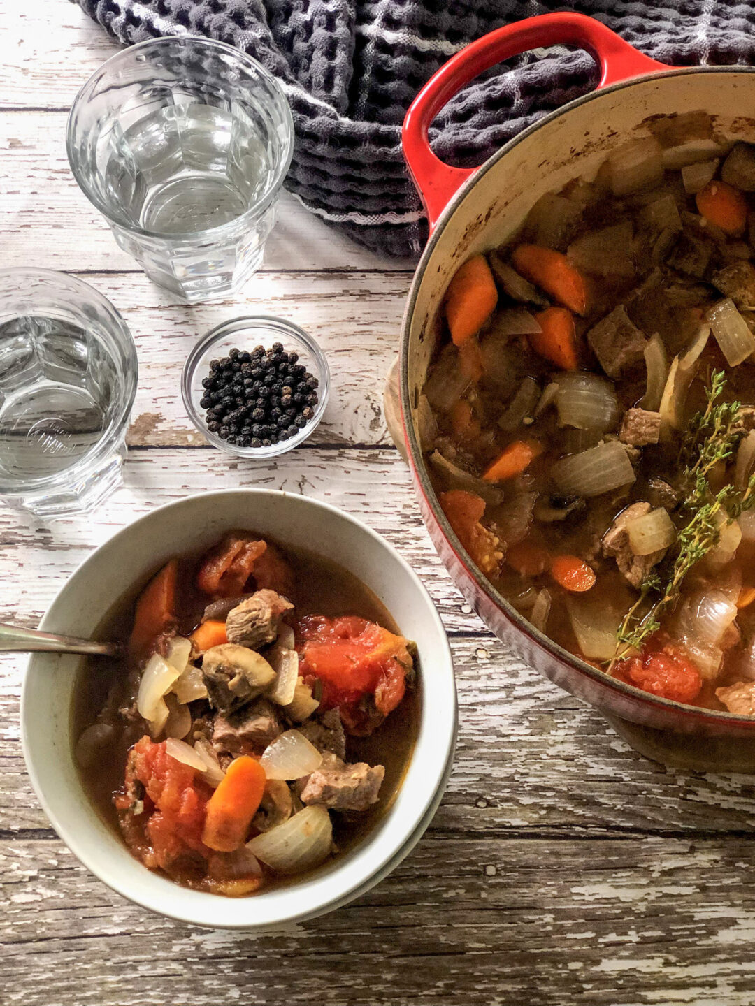 Finished pot of lamb roast next to a bowl filled with lamb roast