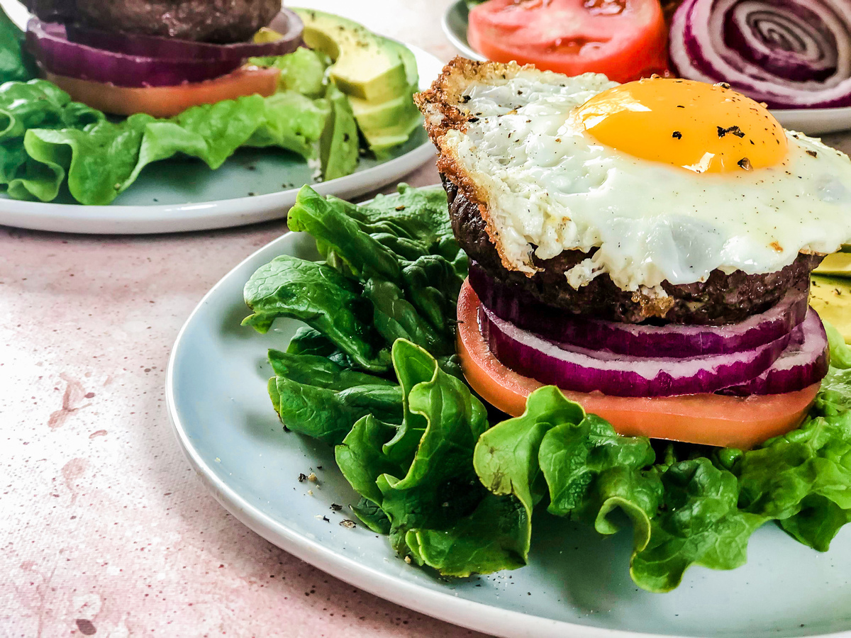 Sage mushroom burgers plated with toppings.