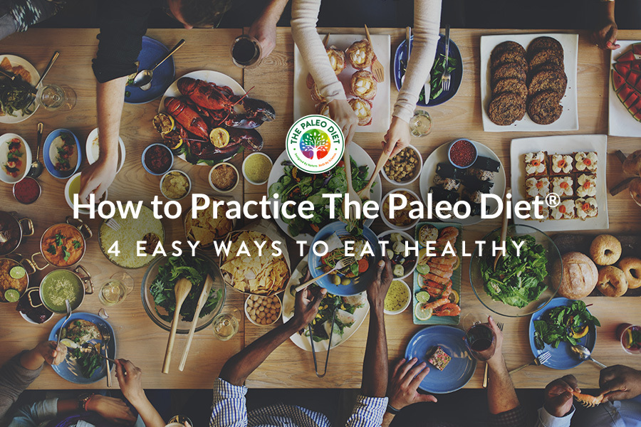 How to Practice The Paleo Diet: A group of people sitting around a table of healthy foods