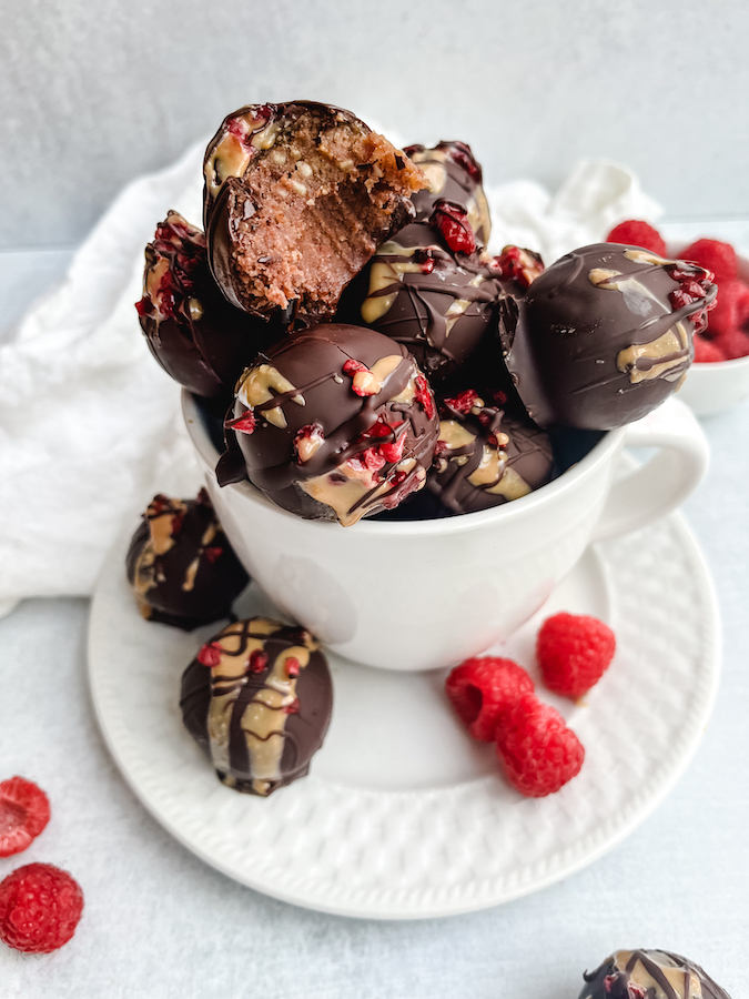 Dark Chocolate Raspberry Truffles in a bowl with one missing a bite
