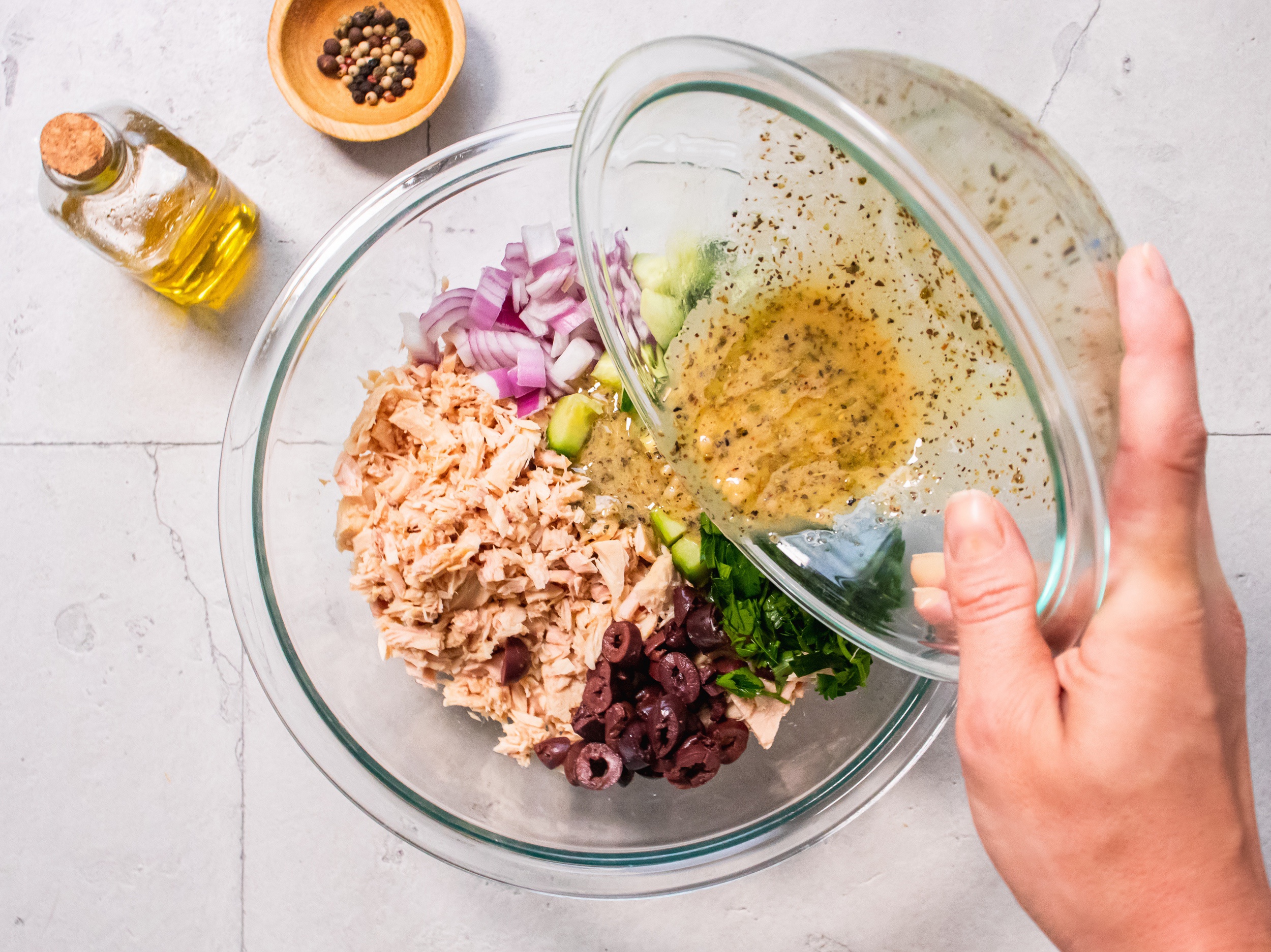 Pouring dressing onto ingredients for tuna salad lettuce wraps