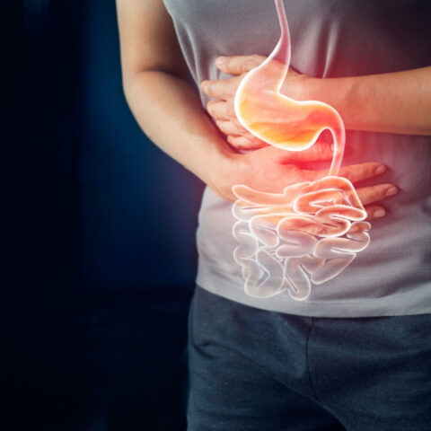 Photo illustration of a person holding a stomach that is in pain.