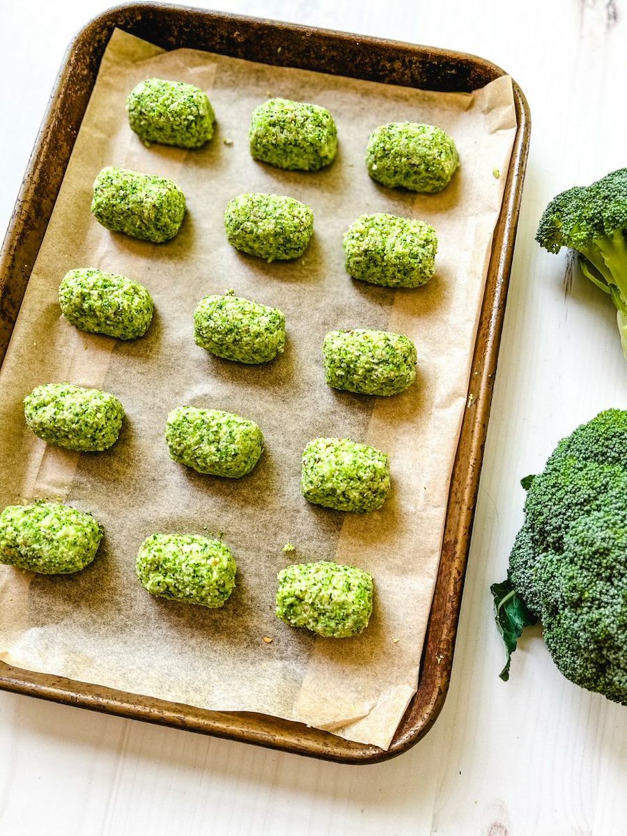 Broccoli tots prepped on a baking sheet