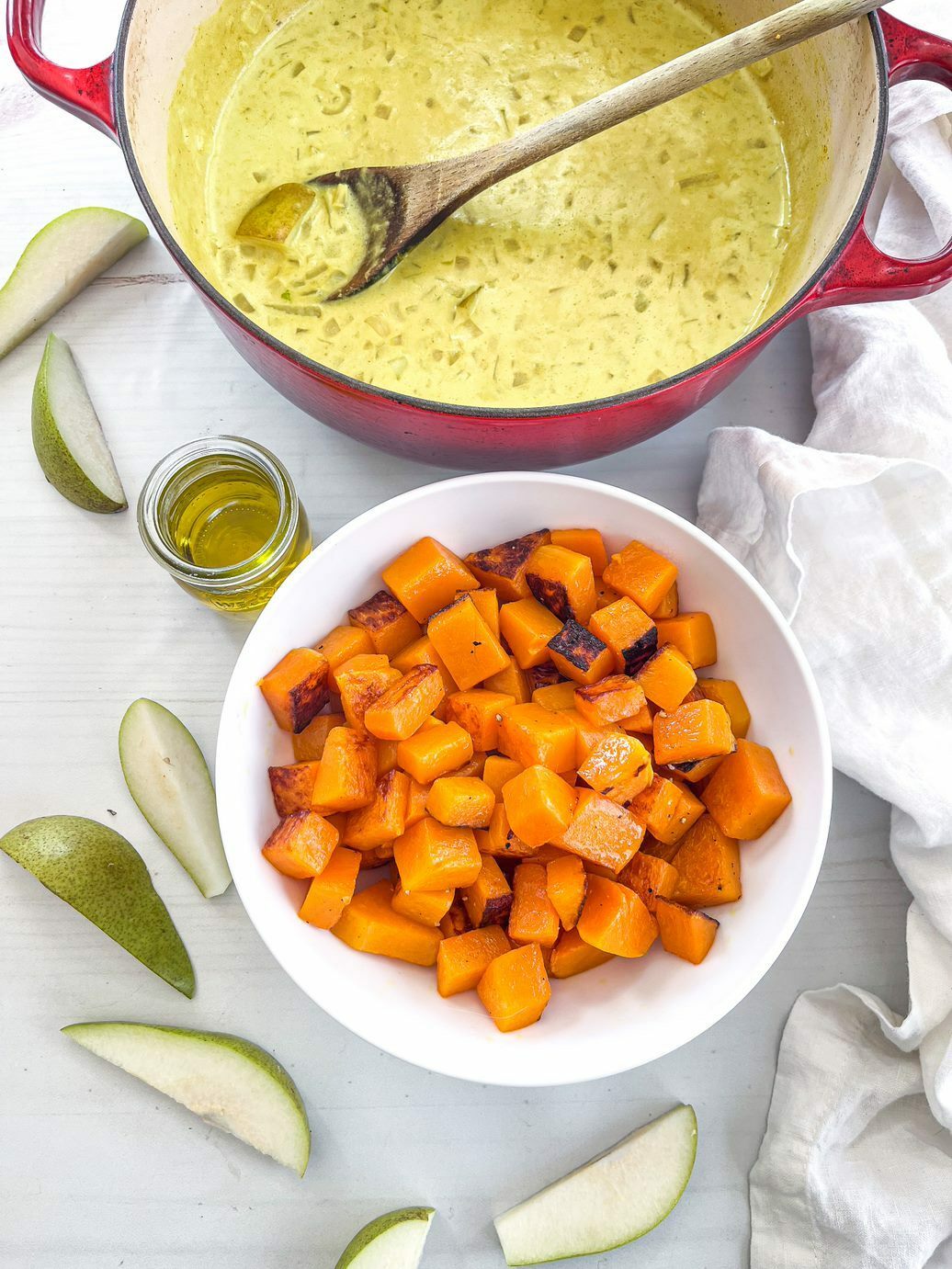 Chopped butternut squash with soup prepped in a separate pot