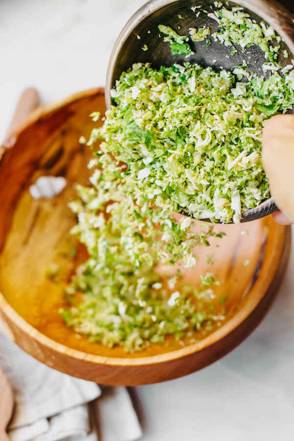 Brussels sprouts being poured into a wooden bowl