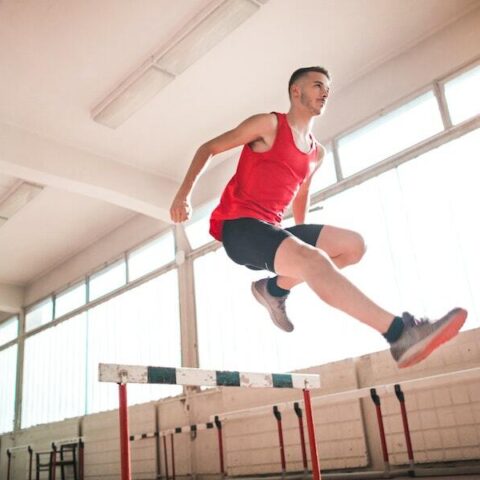 A man jumping over a hurdle.