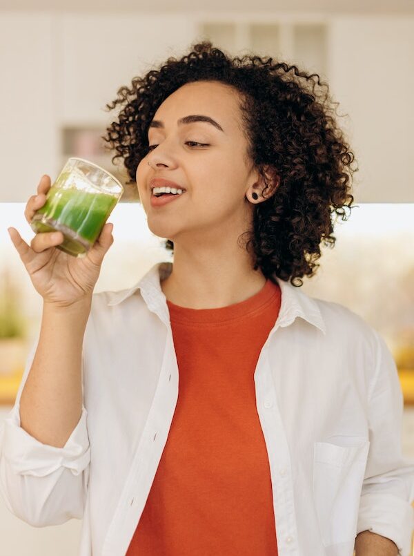 women-smiling-while-drinking-a-green-juice