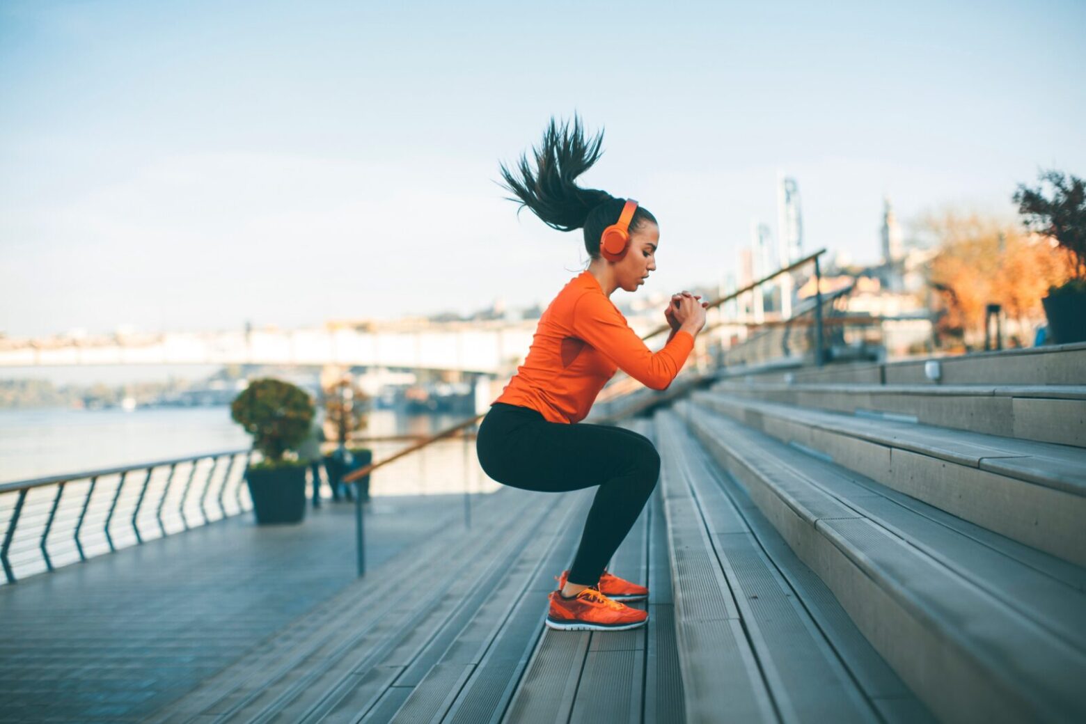 Woman jumping steps on a river bank.