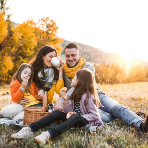 A family enjoying a fall picnic in the mountains at sunset.
