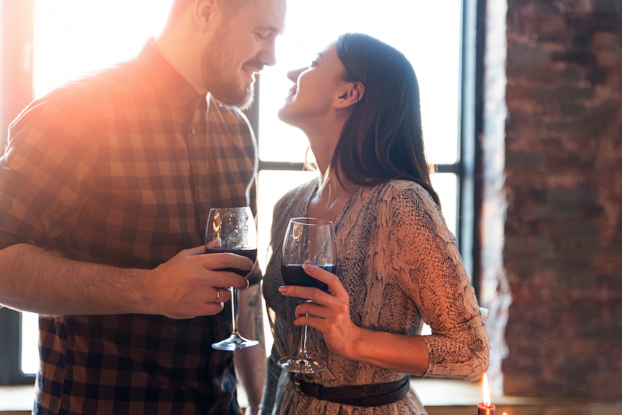 A couple drinking wine enjoying valentine's day together.