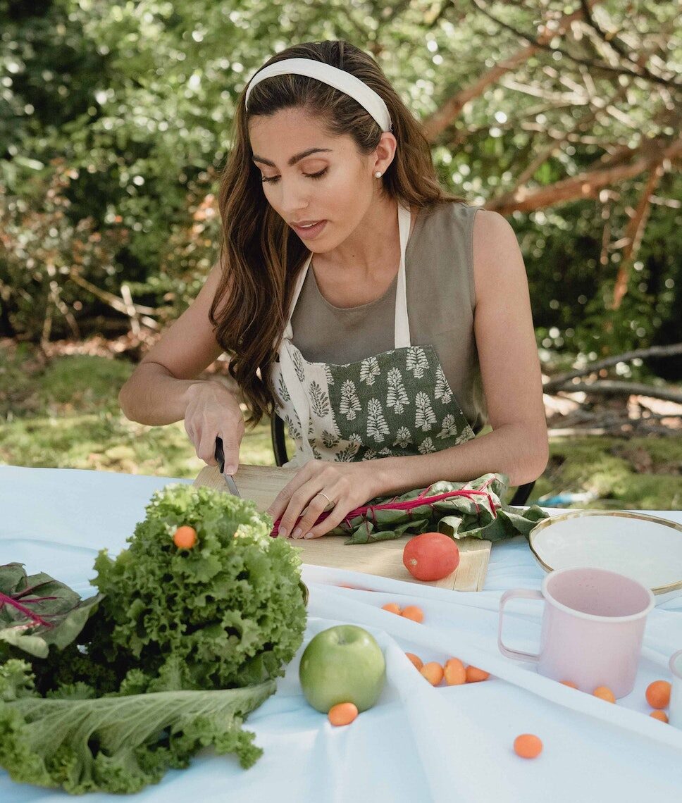 women chopping veggies in her backyard