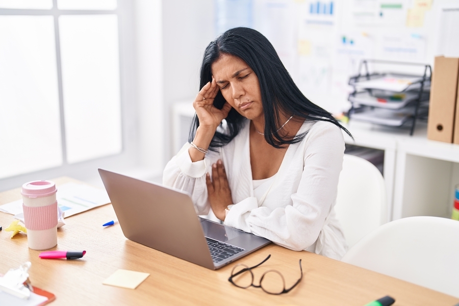 Woman feeling tired at her desk.