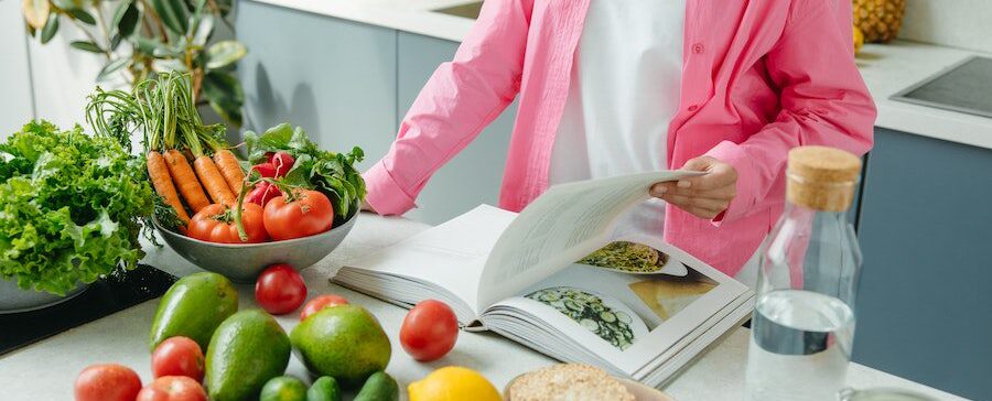 women-reading-cookbook-with-vegetables