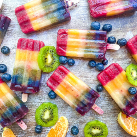 rainbow popsicles on counter with fruits