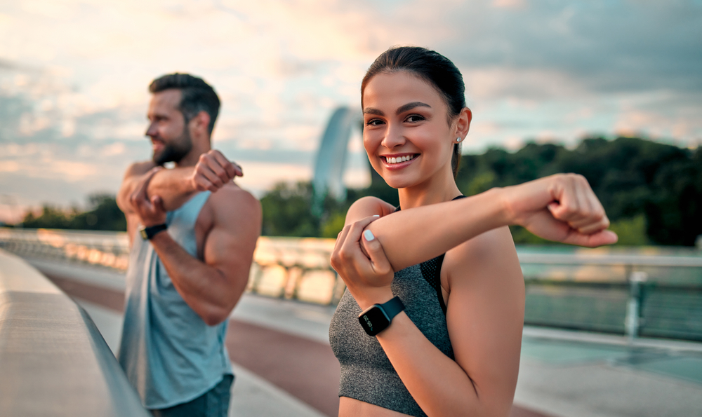 Woman and Man Stretching Before a Run