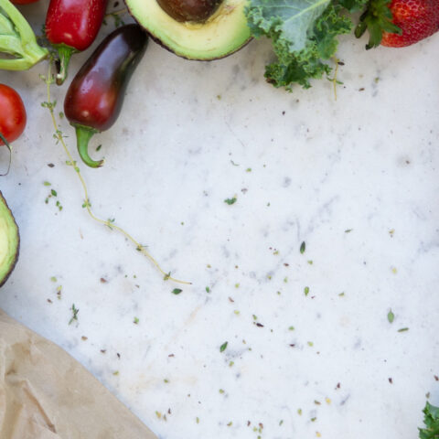 Fresh fruits and vegetables on a white marble countertop