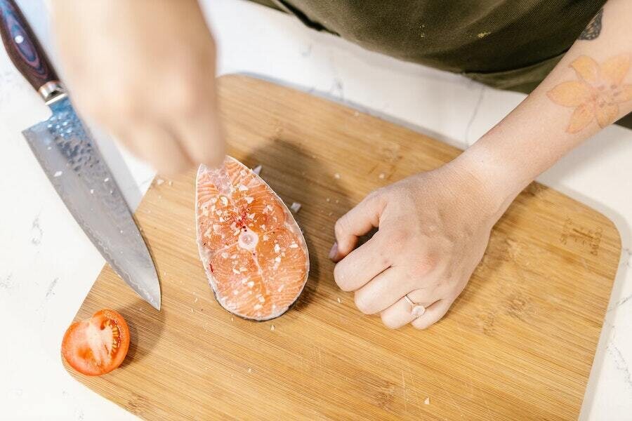 salting a fish on a cutting board