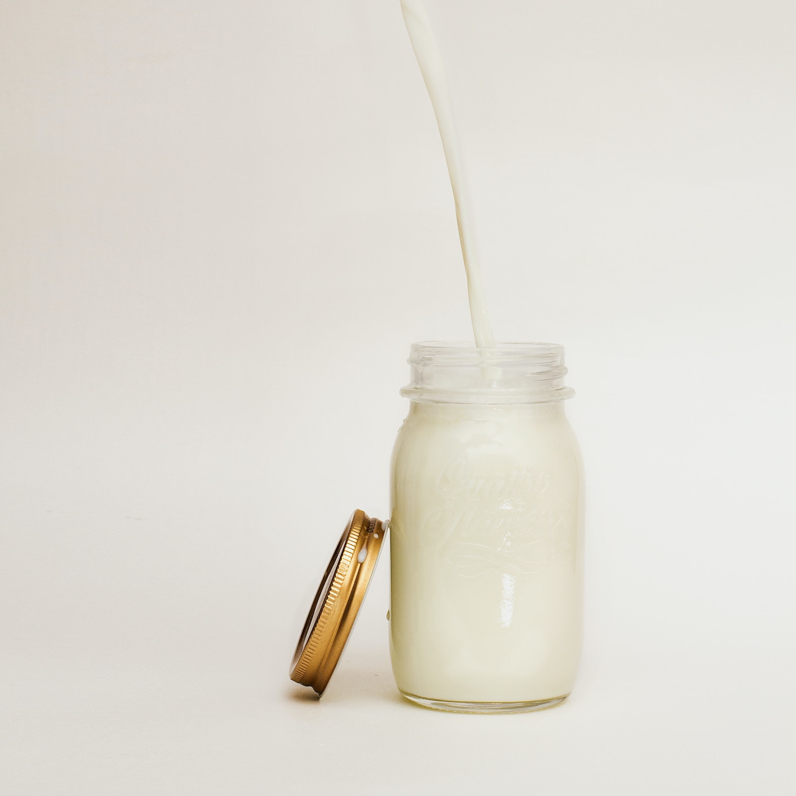 milk being poured into a mason jar