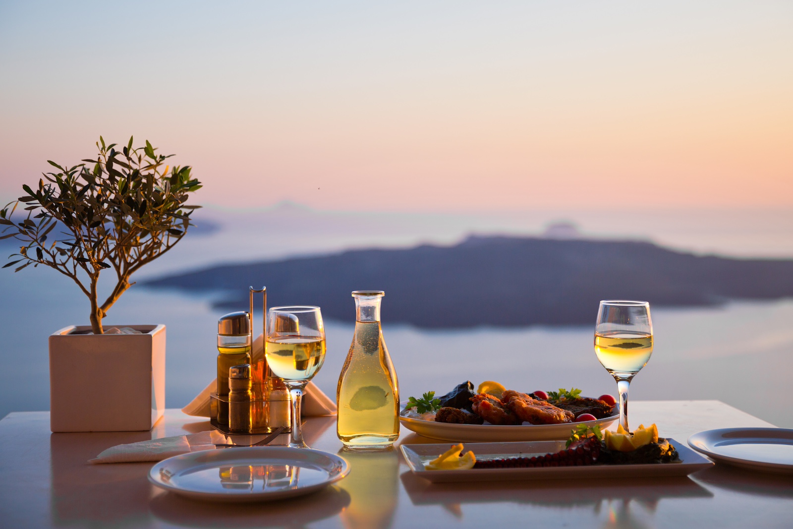 A romantic dinner setting overlooking the Mediterranean Sea at sunset