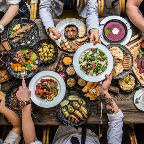 Above shot of friends and family having dinner at a long wooden table.