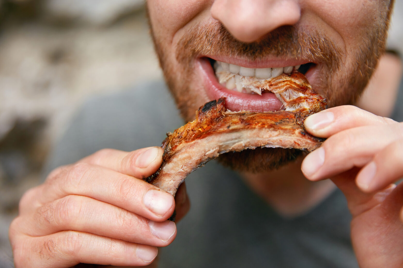 Close-up of a man eating ribs