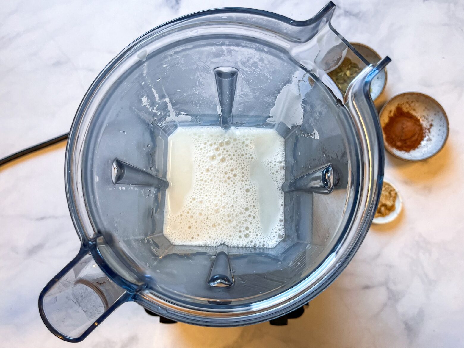 Almond milk being blended with other ingredients to make a latte.