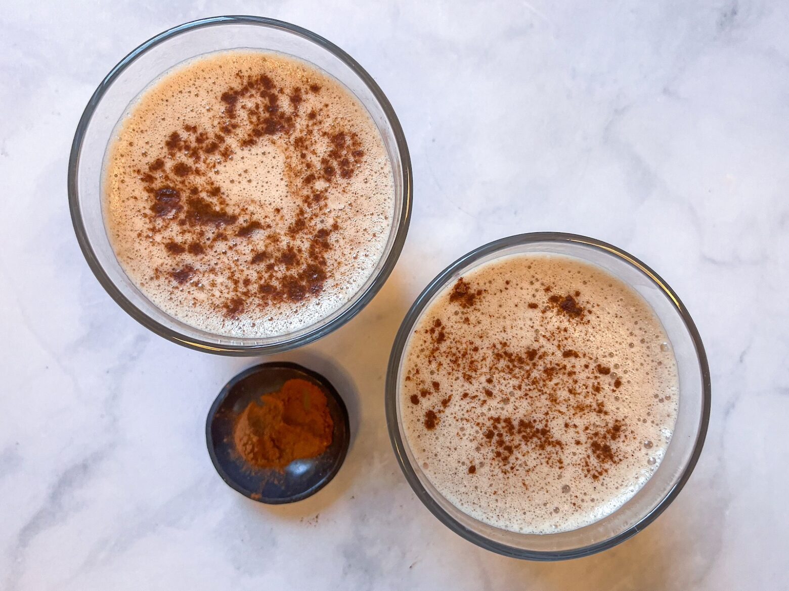 Two cacao reishi lattes in glasses ready to drink.