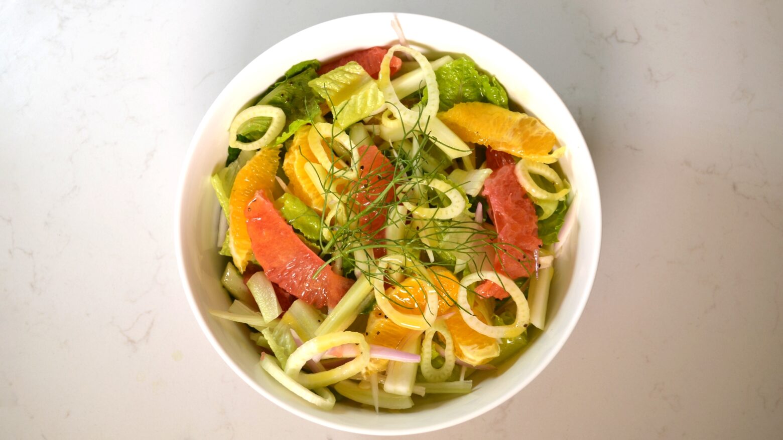 Above shot of a salad with slices of orange and grapefruit.