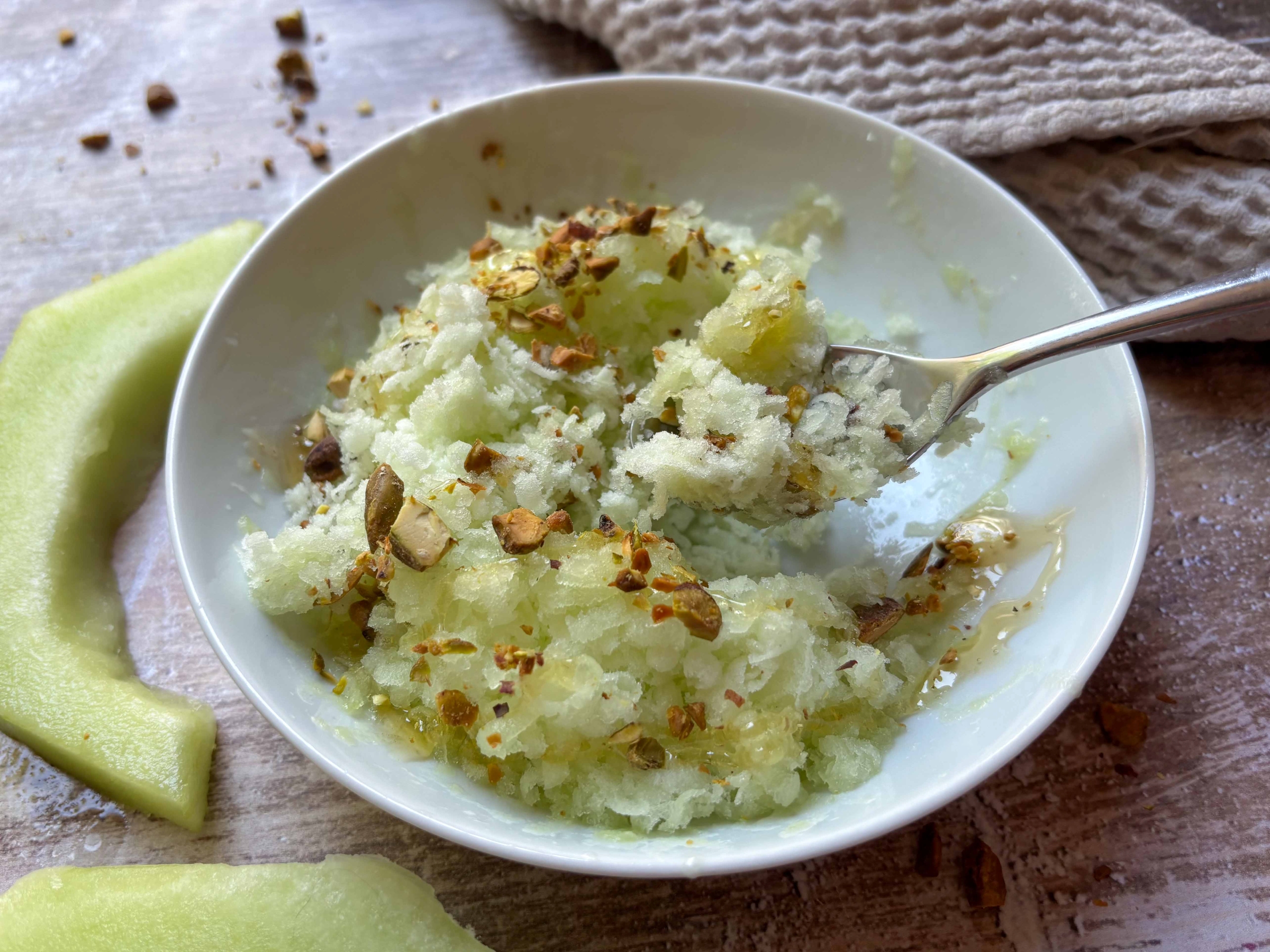 A spoonful of honeydew granita with pistachios
