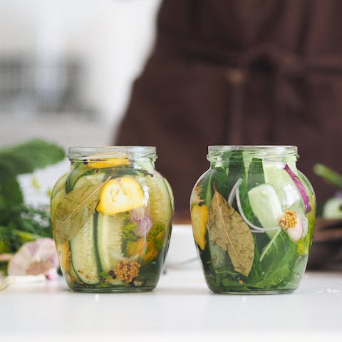 Clear Glass Jar With Green Leaves and Pickled Vegetables.